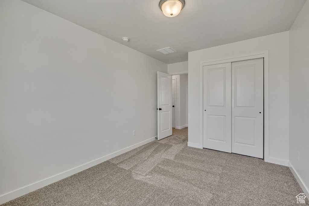 Unfurnished bedroom featuring carpet flooring and a closet