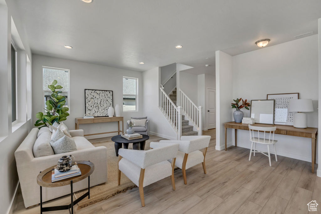 Living area with light wood-style floors, stairs, recessed lighting, and an office area