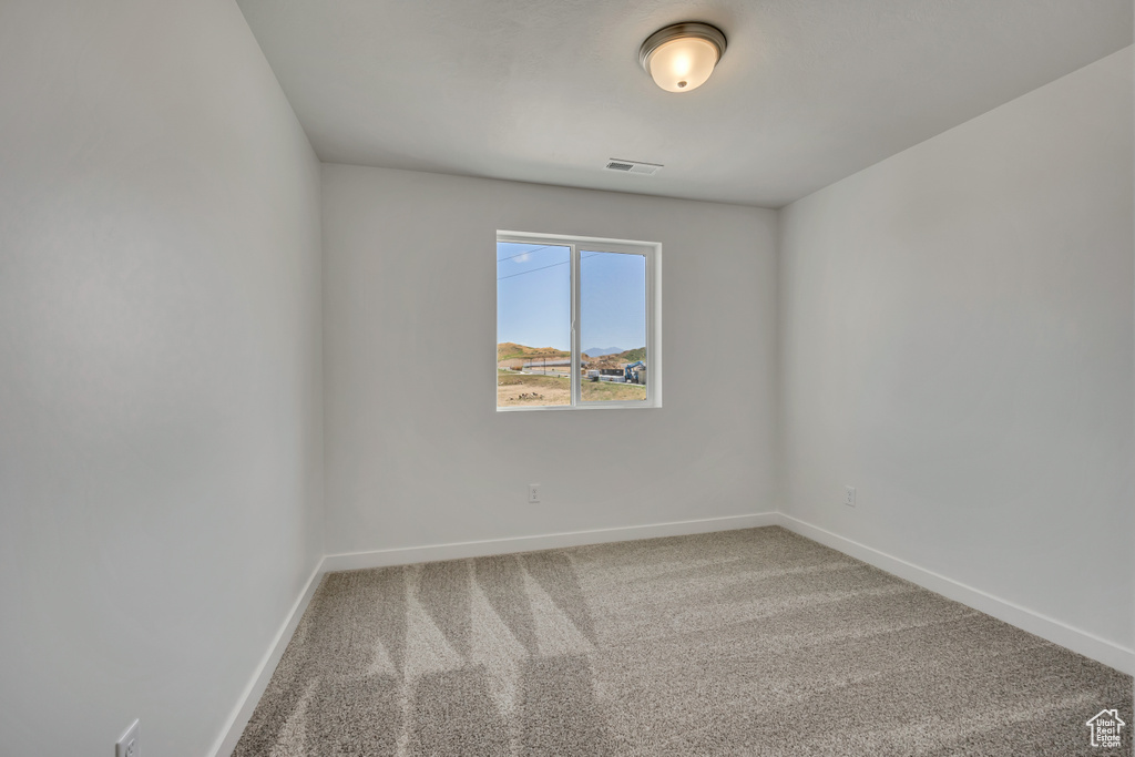 Carpeted spare room with baseboards