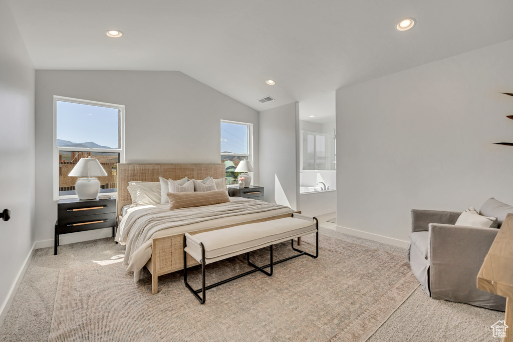 Carpeted bedroom featuring vaulted ceiling, multiple windows, recessed lighting, and connected bathroom
