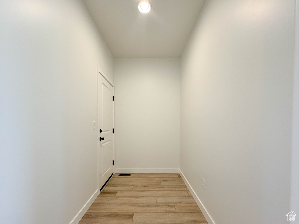 Laundry room with light wood-style floors and baseboards