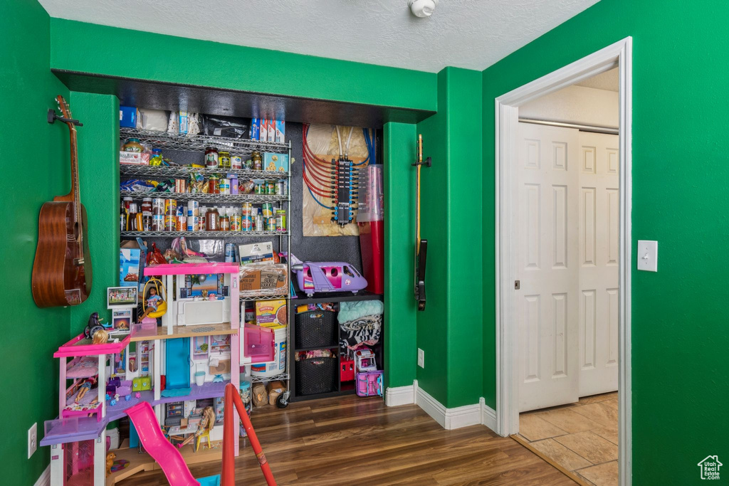Game room with wood finished floors and a textured ceiling