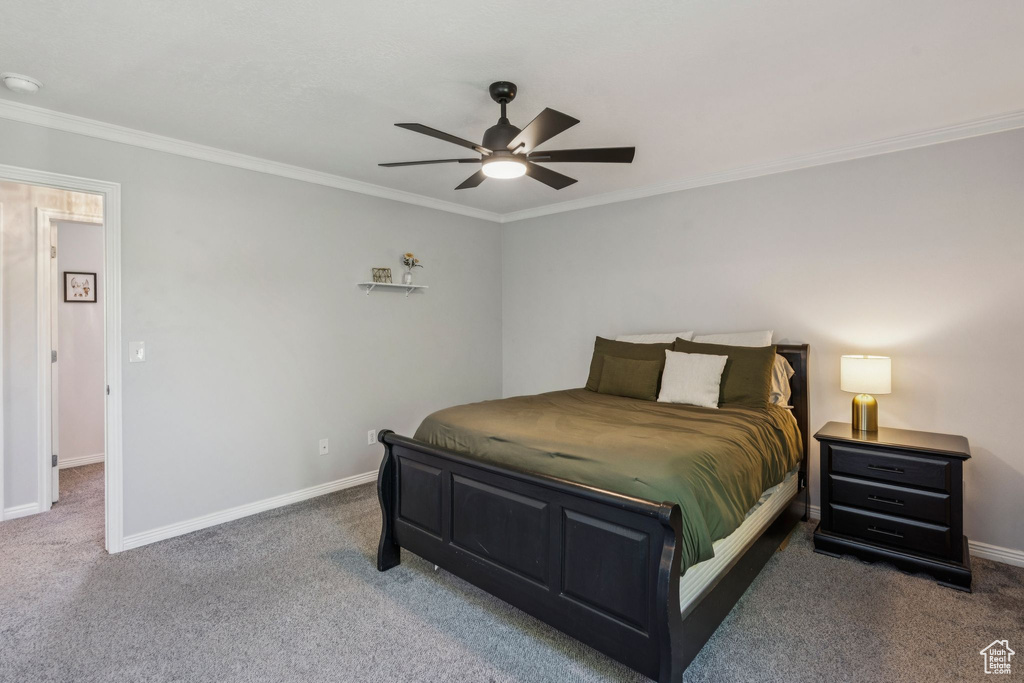 Carpeted bedroom featuring crown molding and a ceiling fan