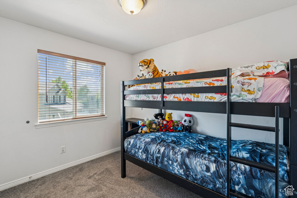 Bedroom featuring carpet floors and baseboards