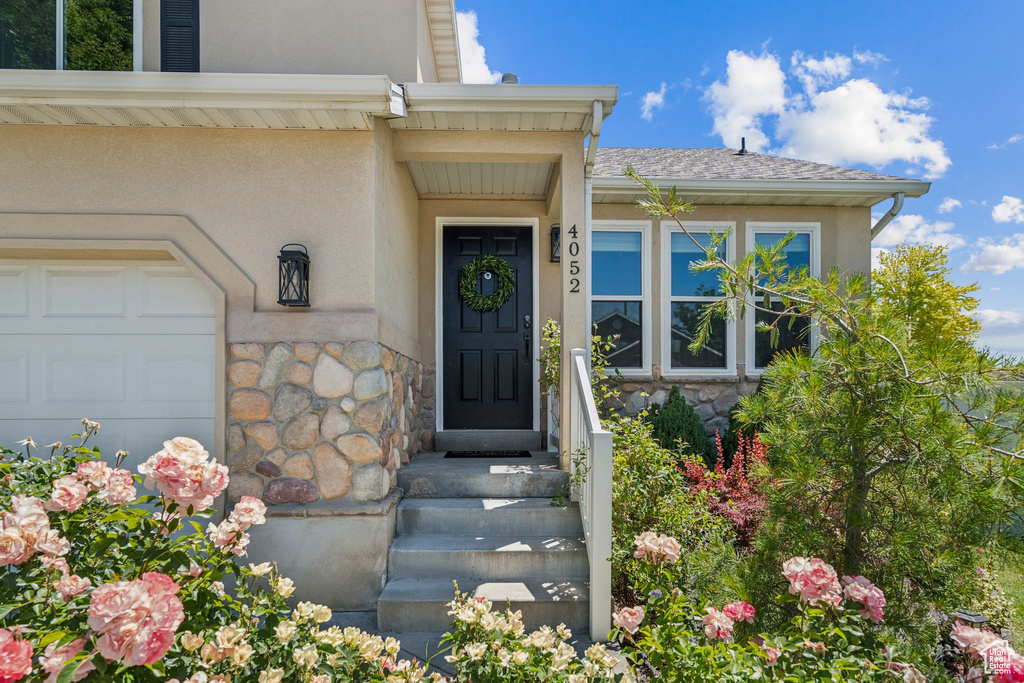 Property entrance with stone siding and stucco siding
