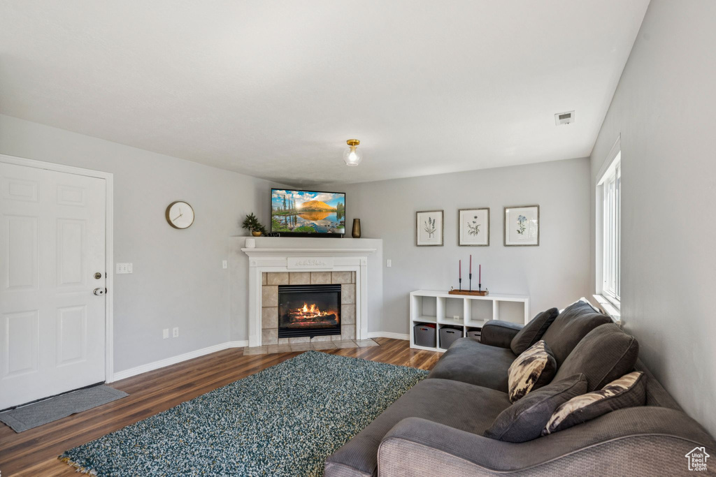 Living area featuring dark wood-type flooring and a tile fireplace