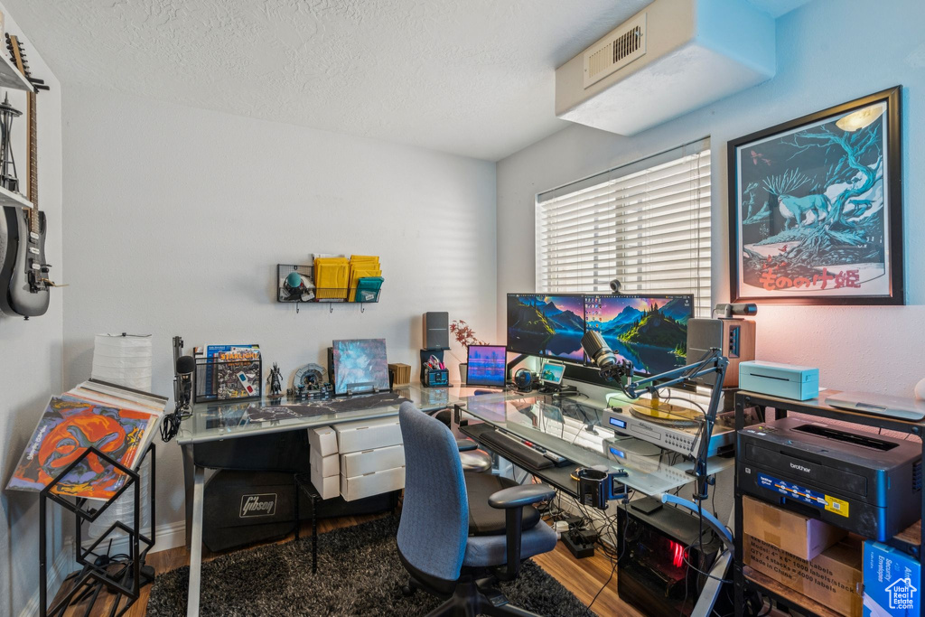 Office space with wood finished floors and a textured ceiling