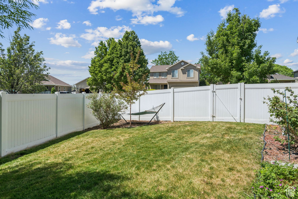Fenced backyard featuring a gate and a residential view