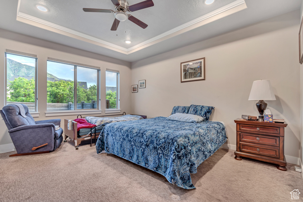 Bedroom with a raised ceiling, ornamental molding, carpet floors, recessed lighting, and a ceiling fan