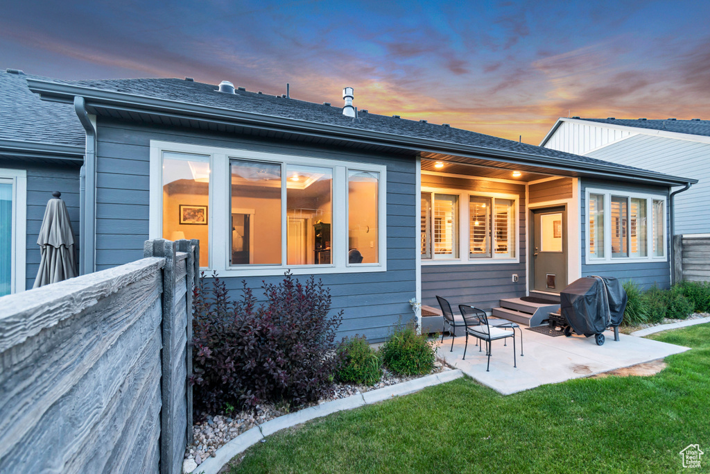 Rear view of house with a patio area and a shingled roof
