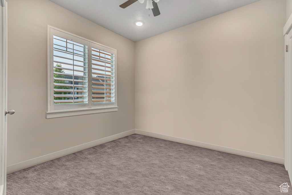 Unfurnished room with a ceiling fan, carpet flooring, and baseboards
