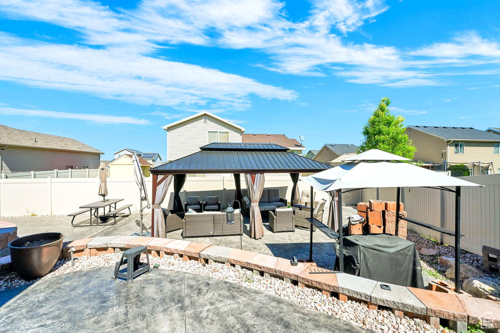 Dock area featuring an outdoor living space, a gazebo, a fenced backyard, and a patio