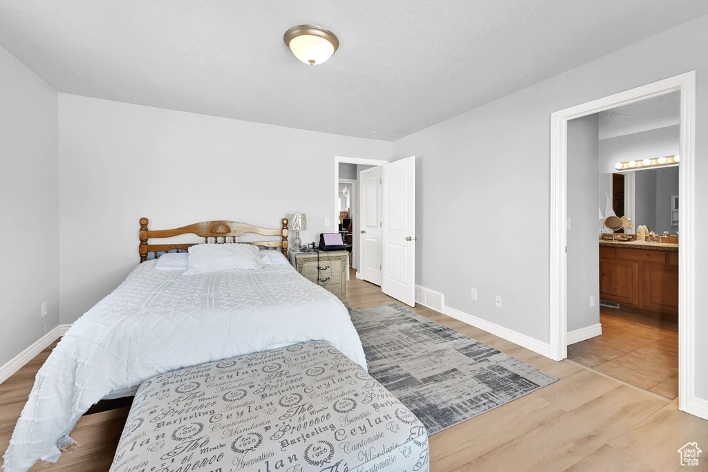 Bedroom featuring wood finished floors and ensuite bathroom