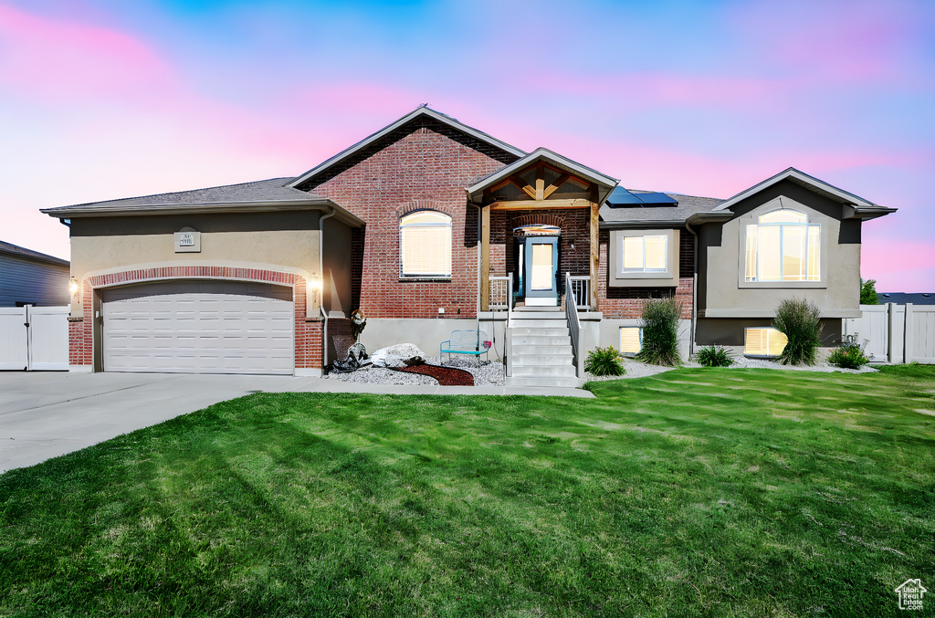View of front facade with concrete driveway, solar panels, brick siding, and stucco siding