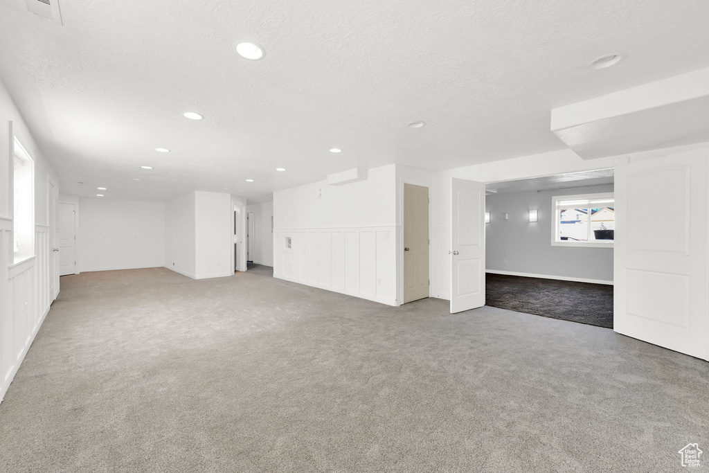 Basement featuring carpet floors, recessed lighting, and a textured ceiling