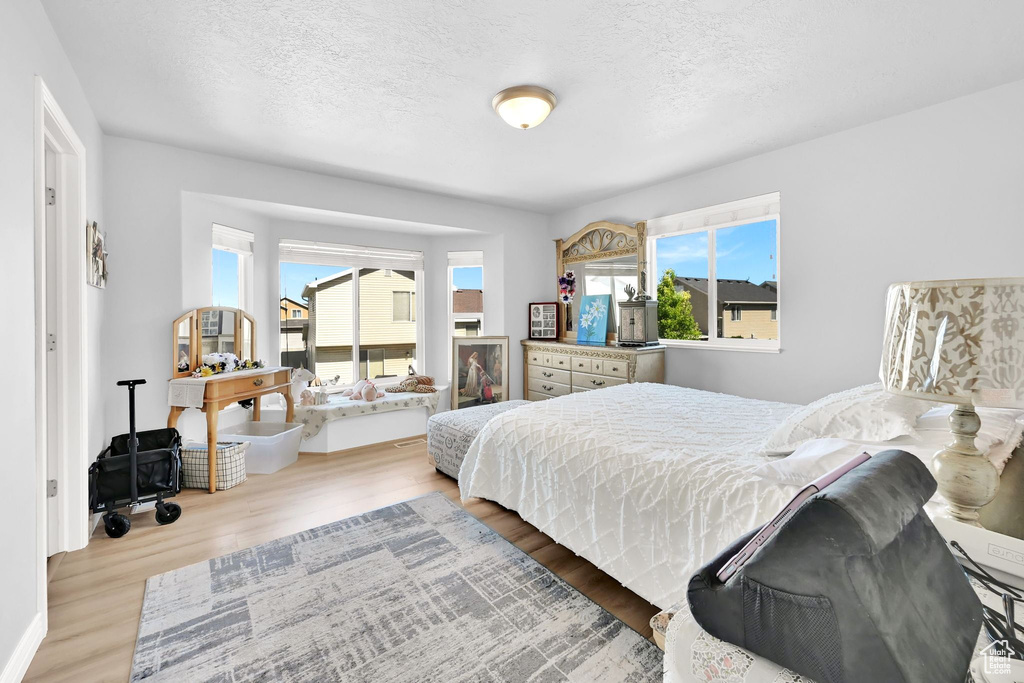 Bedroom with wood finished floors and a textured ceiling