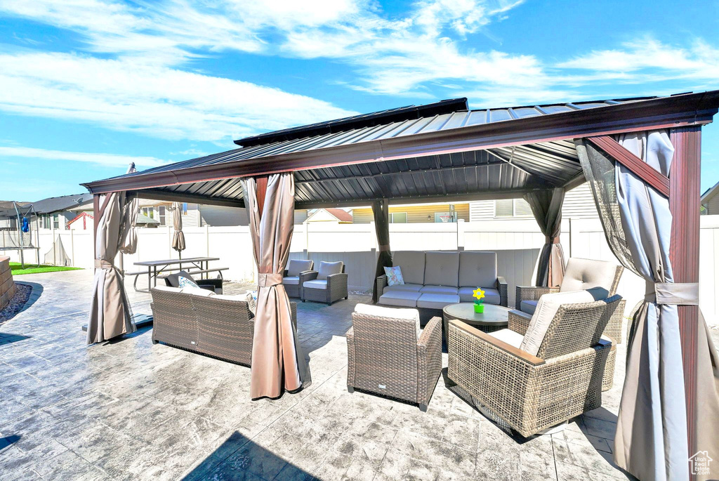 Fenced backyard featuring a gazebo, outdoor lounge area, and a patio