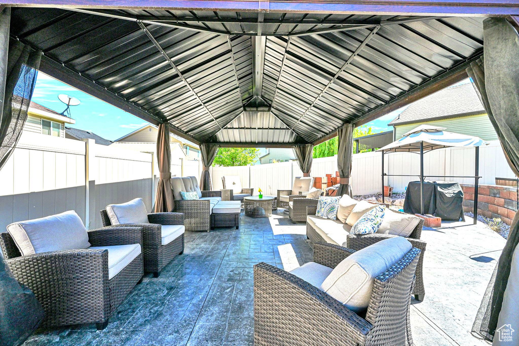 Fenced backyard featuring an outdoor living space, a gazebo, and a patio