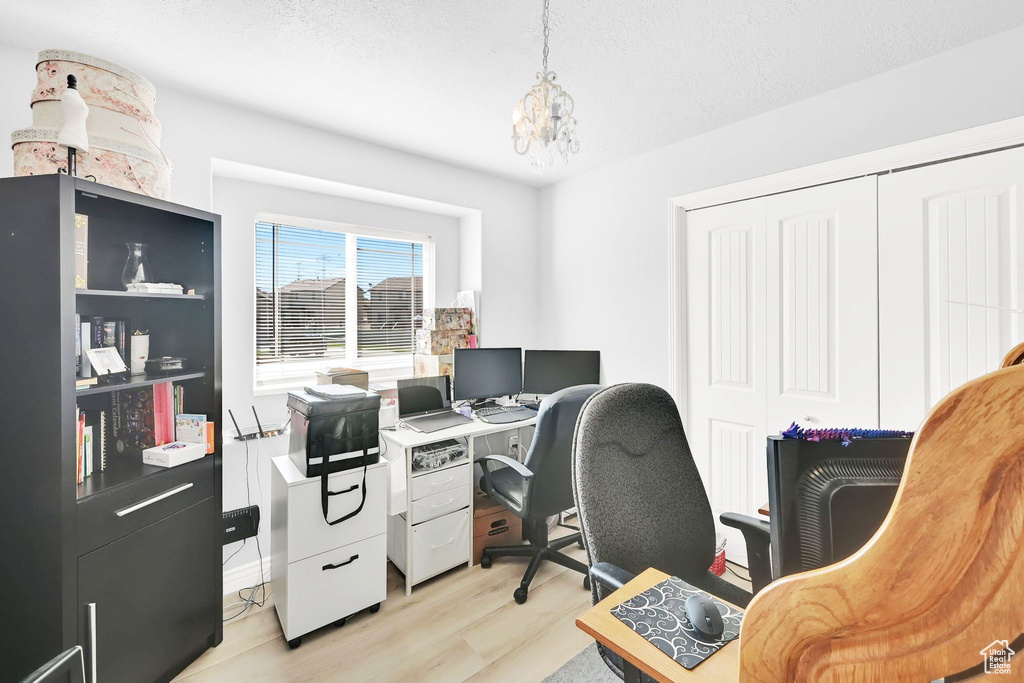 Office area featuring light wood finished floors and a chandelier
