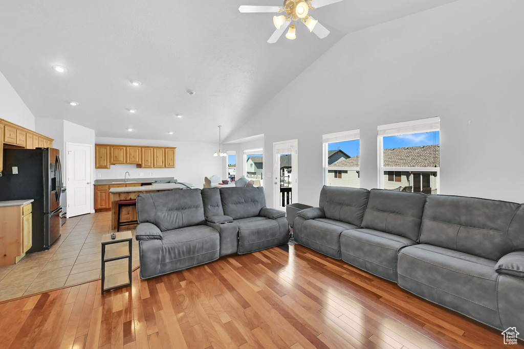 Living area featuring ceiling fan, light wood-type flooring, high vaulted ceiling, and recessed lighting