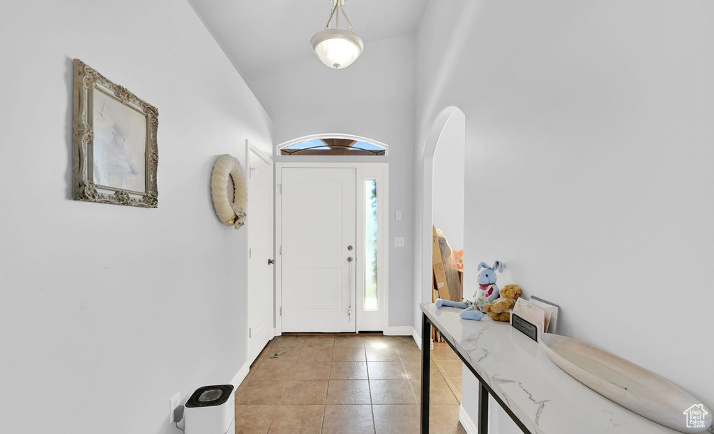 Entrance foyer with light tile patterned flooring and arched walkways