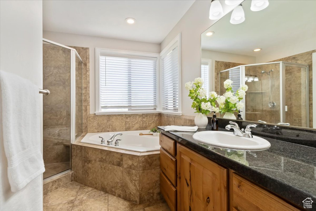 Bathroom featuring vanity, a garden tub, a shower stall, and recessed lighting