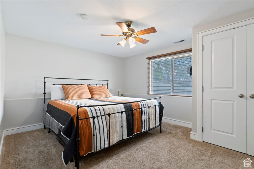 Carpeted bedroom with baseboards and ceiling fan