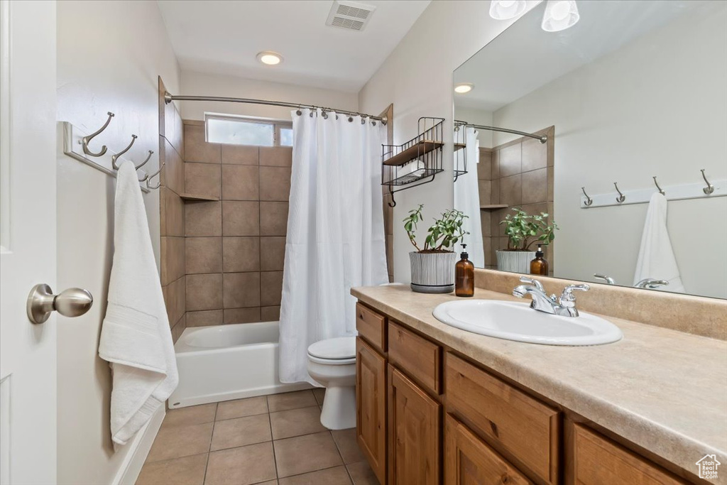 Bathroom featuring vanity, shower / bath combination with curtain, and tile patterned flooring