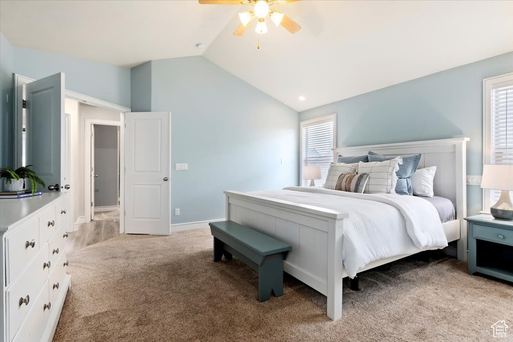 Bedroom featuring lofted ceiling, light colored carpet, and a ceiling fan