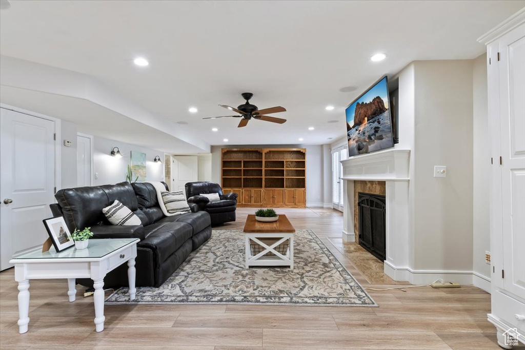 Living area with a fireplace with flush hearth, a ceiling fan, recessed lighting, and light wood finished floors