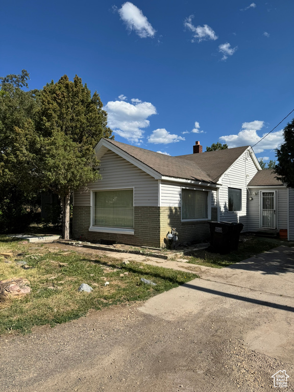 View of front of property with brick siding and a chimney