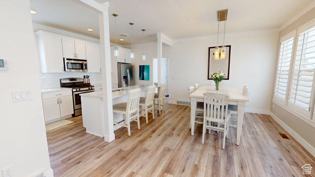 Dining room featuring light wood-style flooring and recessed lighting