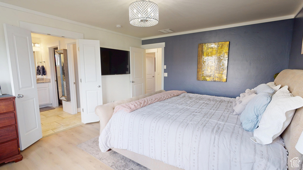Bedroom with light wood finished floors and crown molding