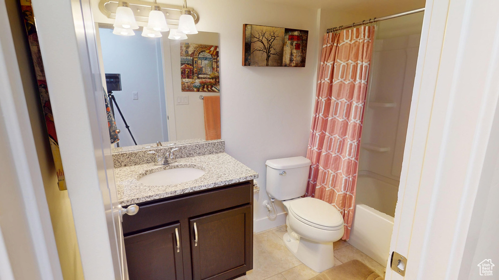 Full bath featuring vanity, tile patterned flooring, shower / bath combo with shower curtain, and a chandelier
