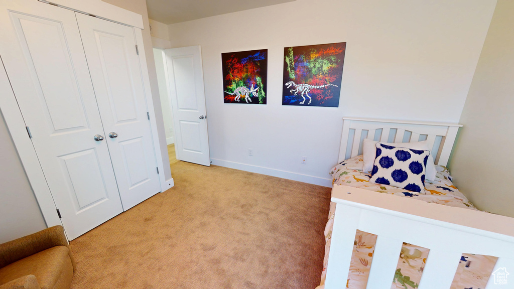 Bedroom featuring light colored carpet and a closet