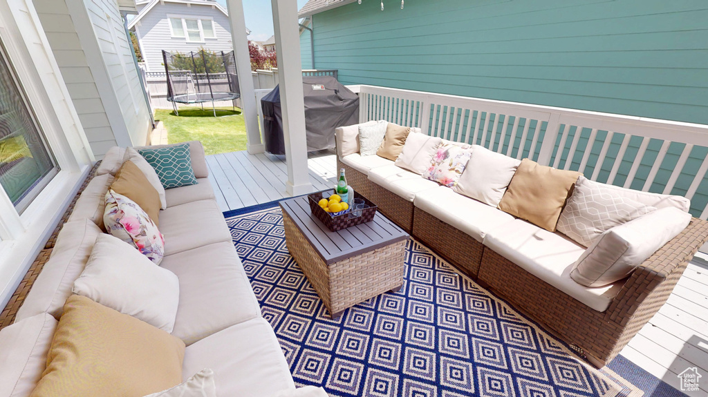Deck featuring a trampoline, outdoor lounge area, and a grill