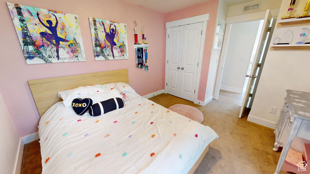 Carpeted bedroom featuring a closet and baseboards