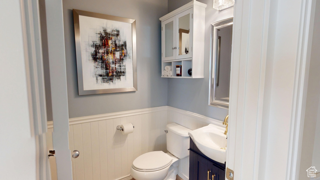 Half bathroom with wainscoting and vanity