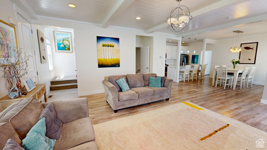 Living room featuring a chandelier, light wood-style flooring, recessed lighting, and a wood ceiling with exposed beams