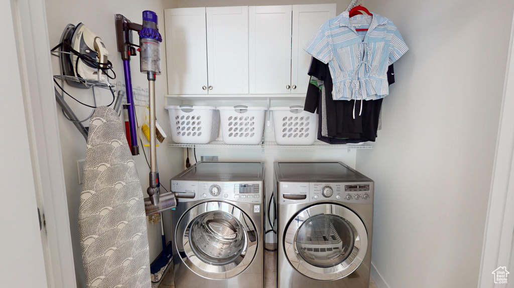 Laundry room featuring separate washer and dryer and cabinet space