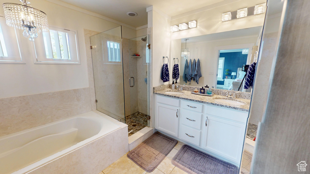 Full bath with a bath, a shower stall, double vanity, healthy amount of natural light, and ornamental molding