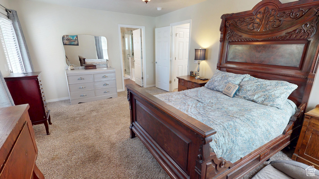 Bedroom featuring light carpet and connected bathroom