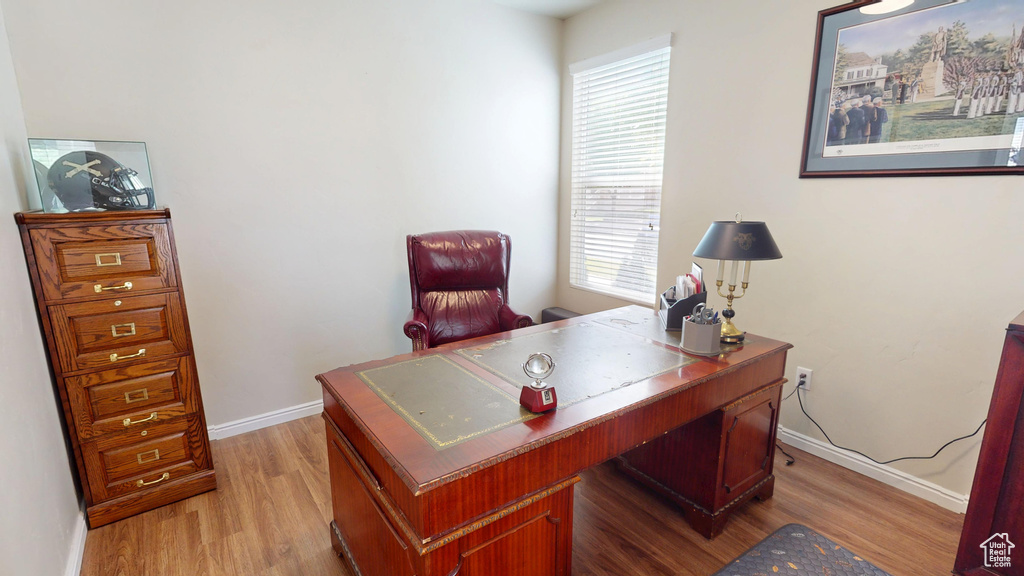 Home office with light wood-style flooring and healthy amount of natural light