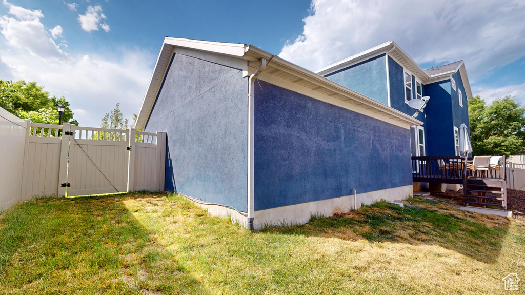 View of home\\\'s exterior with a gate, a deck, and stucco siding