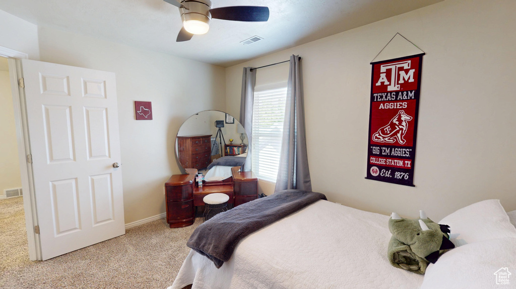 Carpeted bedroom featuring a ceiling fan and baseboards