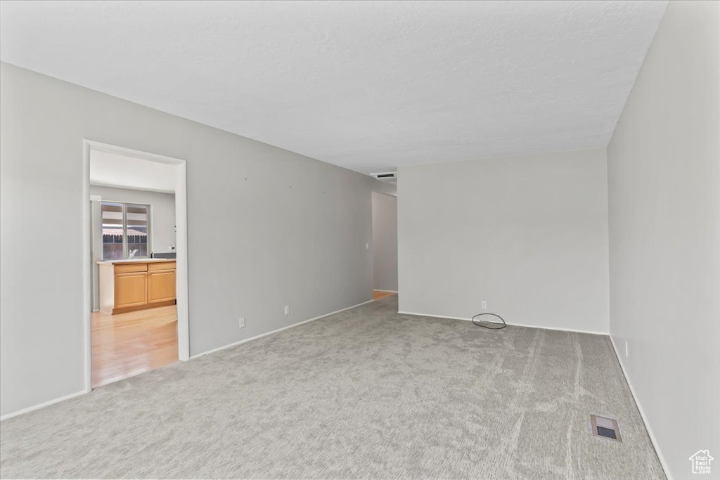 Unfurnished room with light carpet and baseboards