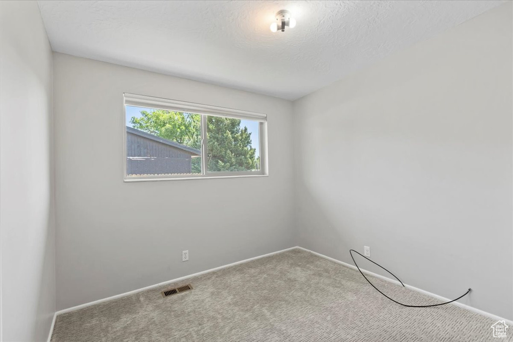 Empty room with carpet and baseboards