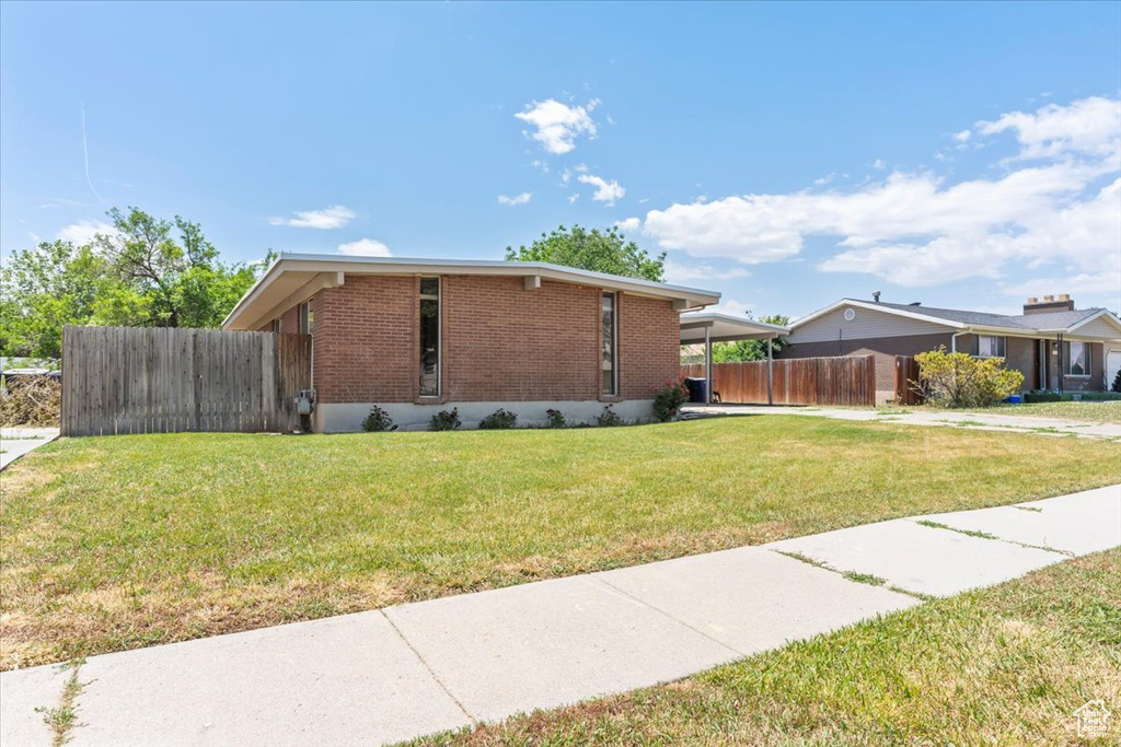 View of side of home with brick siding and an attached carport