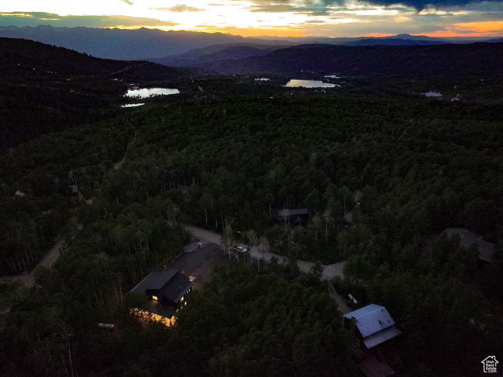 View of property location with a heavily wooded area and a water and mountain view