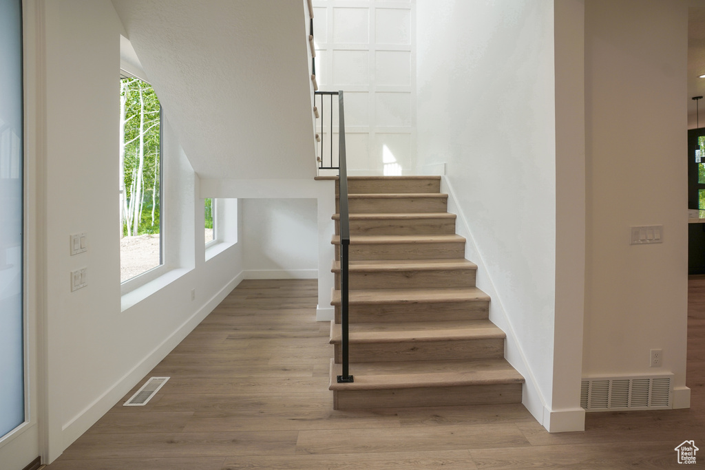 Staircase with baseboards and wood finished floors